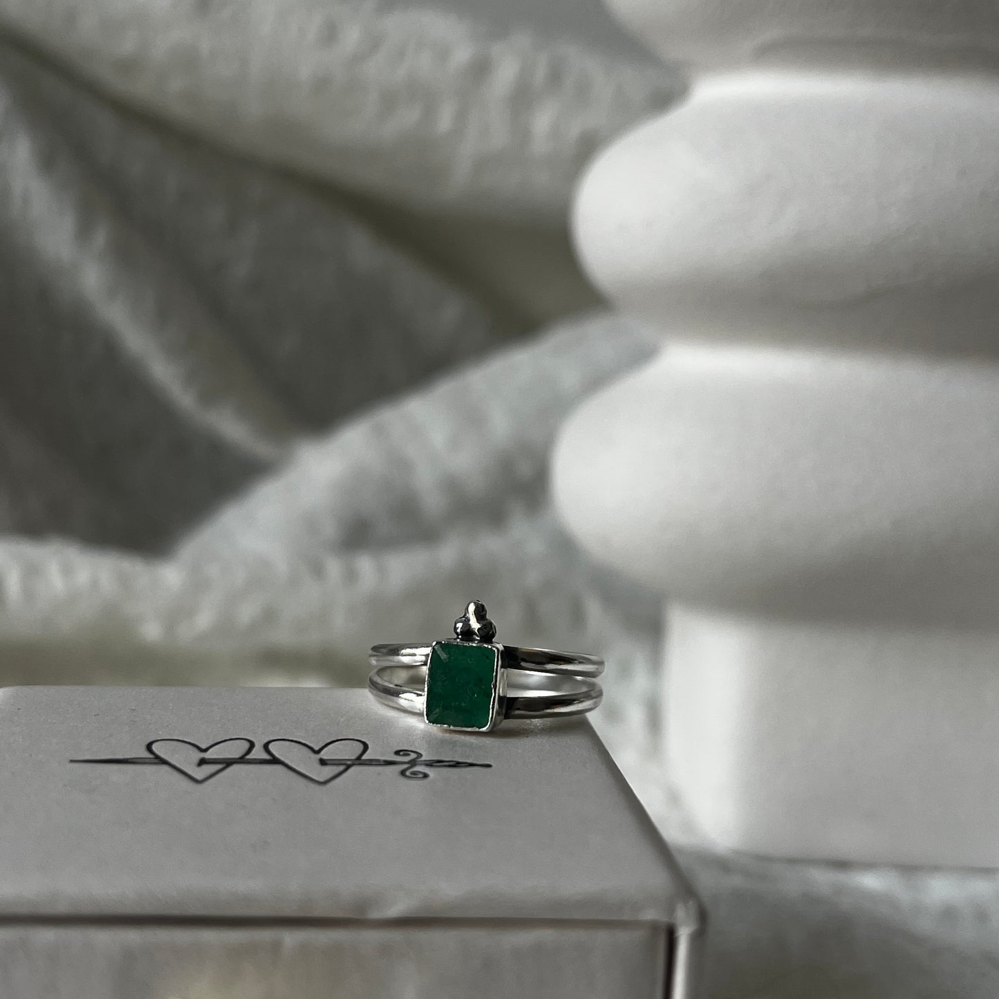 Double band sterling silver ring with a trio dot adornment and a green stone in the center