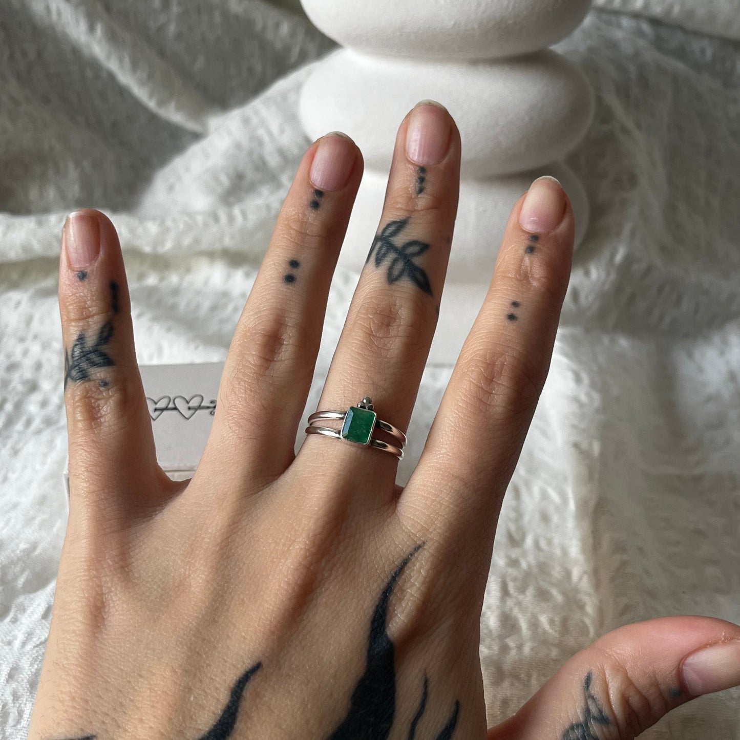 Double band sterling silver ring with a trio dot adornment and a green stone in the center