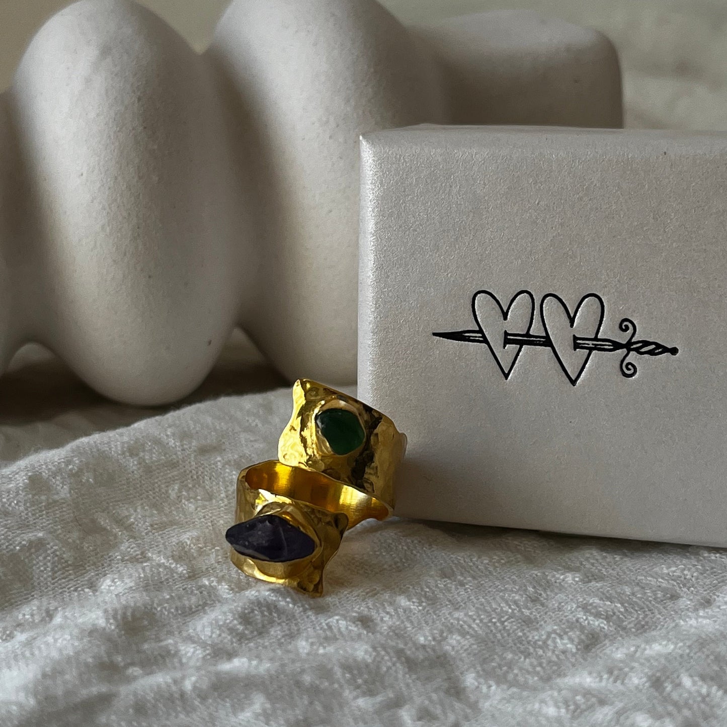 Open band gold plated ring made of sterling silver with a green sea glass in one end and a purple amethyst in the other