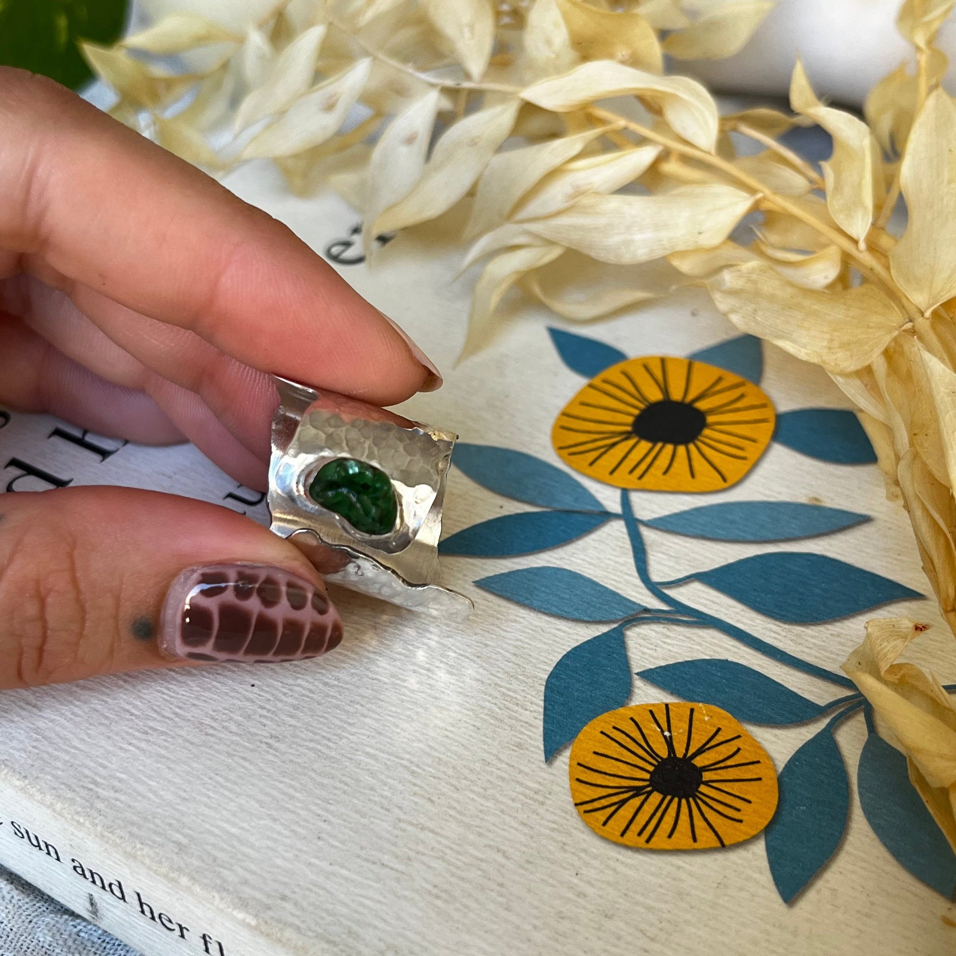 Wide band ring made of sterling silver with a green sea glass center
