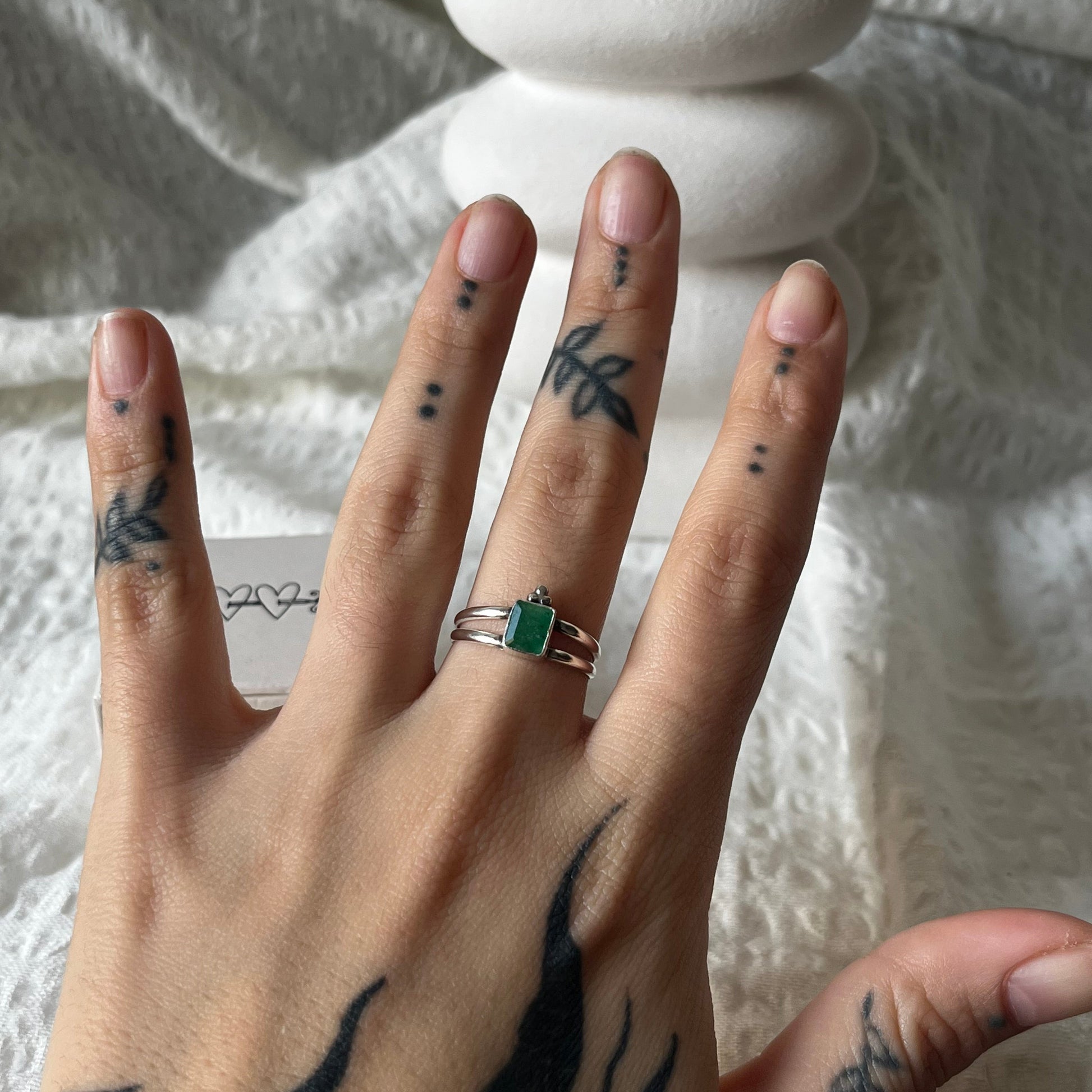 Double band sterling silver ring with a trio dot adornment and a green stone in the center